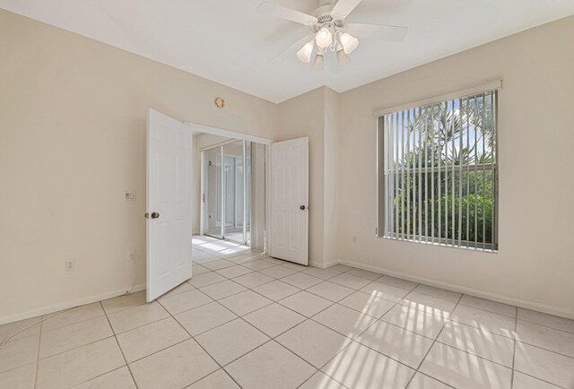 tiled empty room featuring ceiling fan