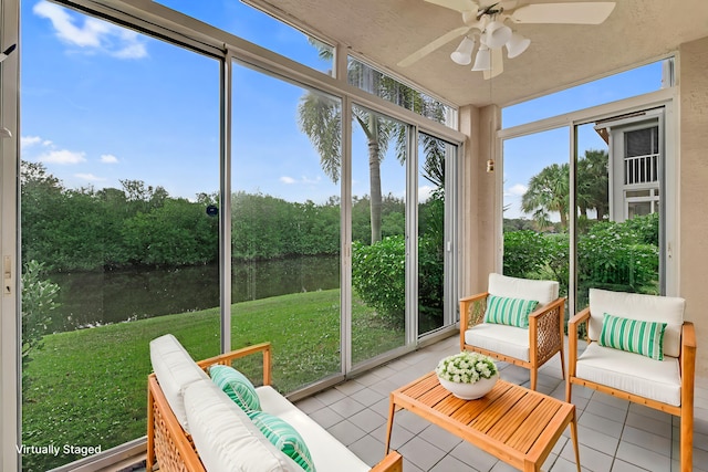 sunroom / solarium featuring a water view and ceiling fan