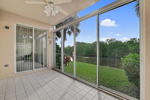 unfurnished sunroom featuring a water view and ceiling fan