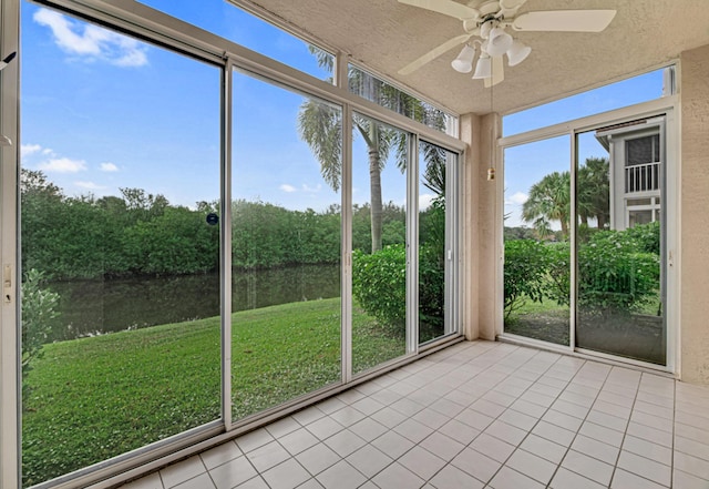 unfurnished sunroom featuring a water view and ceiling fan