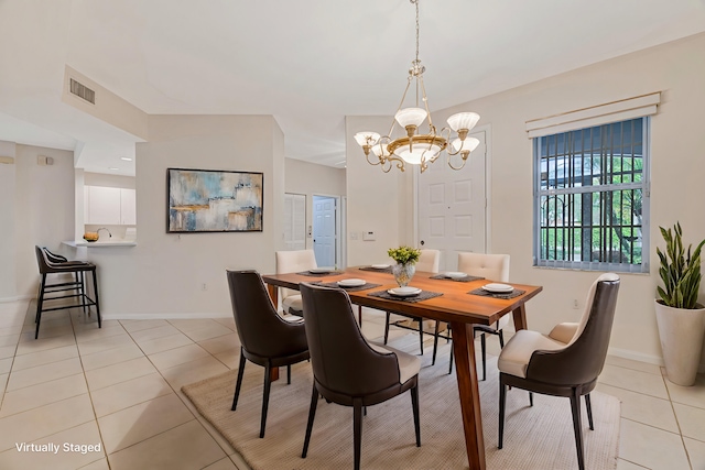 tiled dining space featuring a chandelier