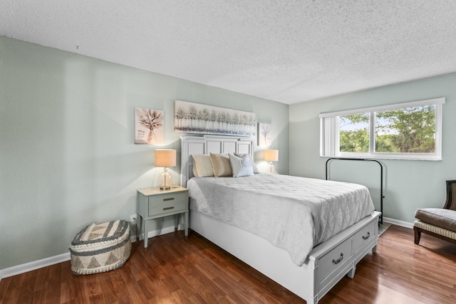 bedroom featuring a textured ceiling and dark hardwood / wood-style floors