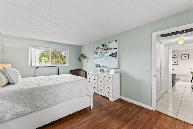 bedroom with a textured ceiling and dark hardwood / wood-style floors