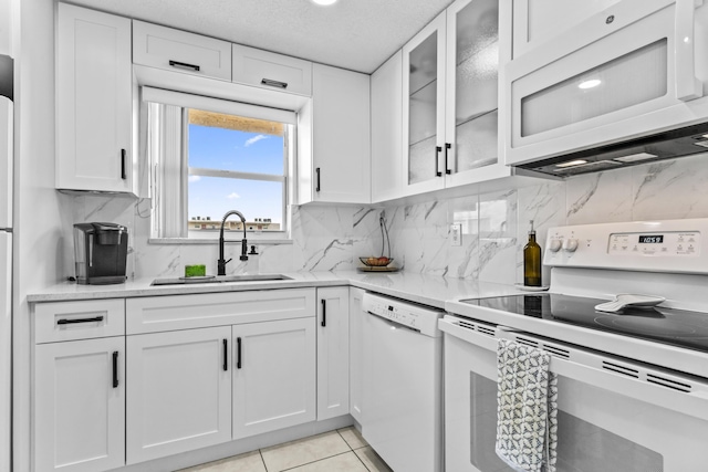 kitchen featuring white appliances, white cabinetry, and light tile patterned flooring