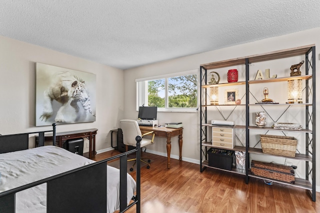 bedroom featuring hardwood / wood-style floors and a textured ceiling