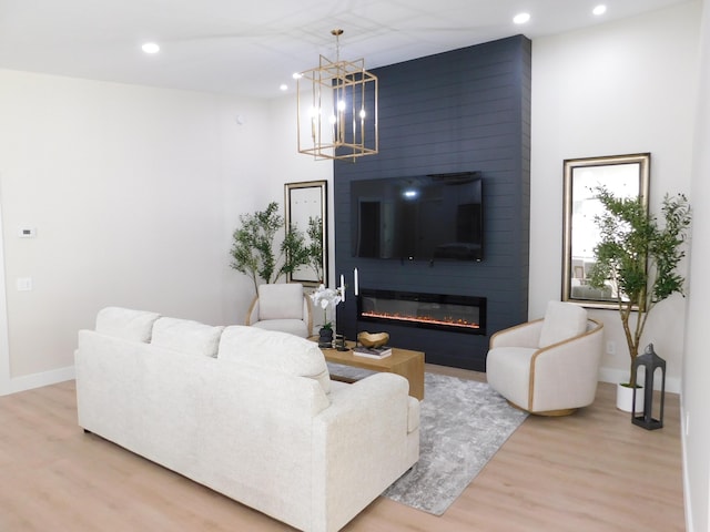 living room featuring hardwood / wood-style flooring, a notable chandelier, and a fireplace