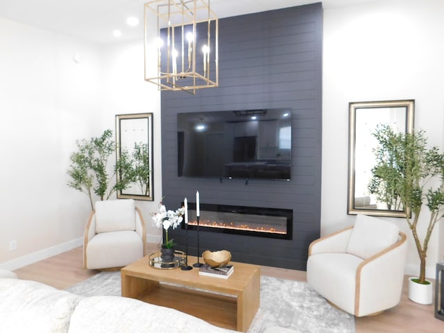 living room with recessed lighting, baseboards, a large fireplace, and wood finished floors