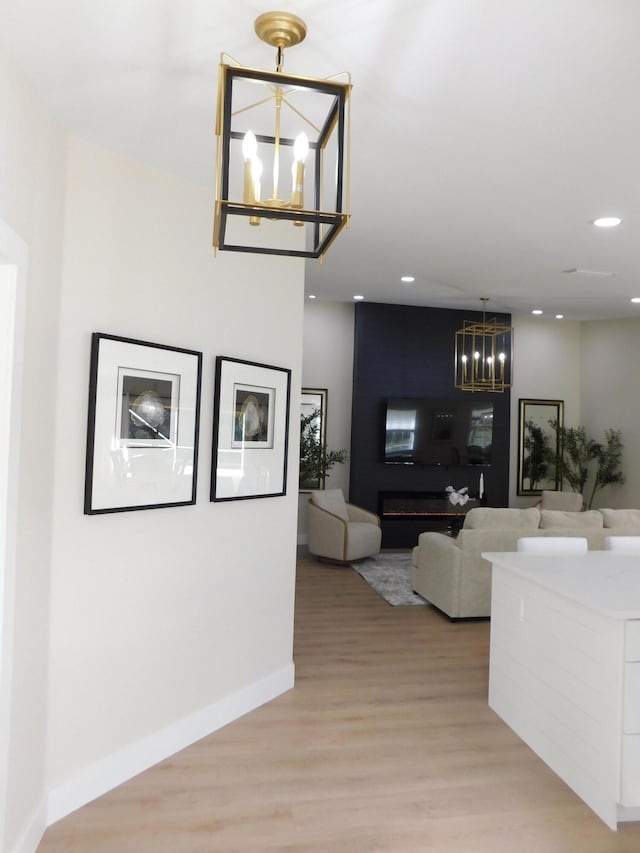 interior space with recessed lighting, light wood-type flooring, baseboards, and an inviting chandelier