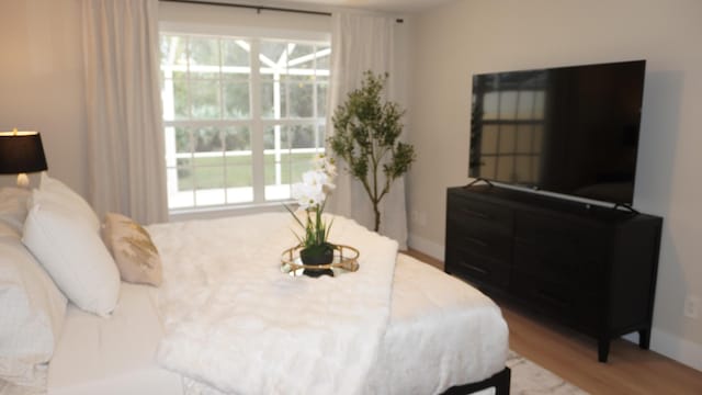 bedroom featuring wood finished floors and baseboards