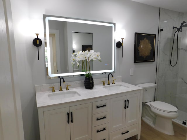 full bath with a sink, a marble finish shower, and toilet