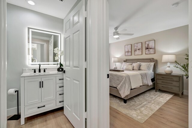 full bath featuring a marble finish shower, toilet, recessed lighting, wood finished floors, and vanity