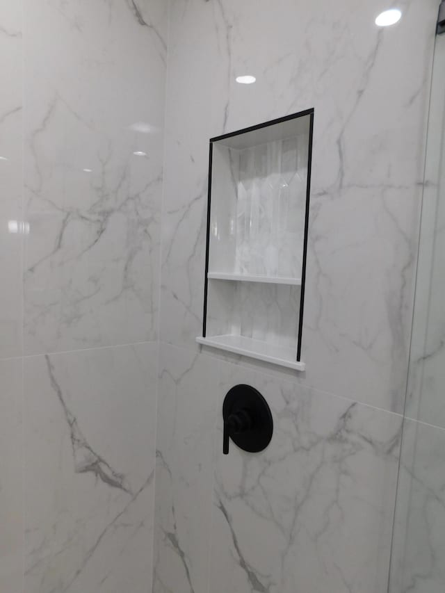 details featuring a marble finish shower