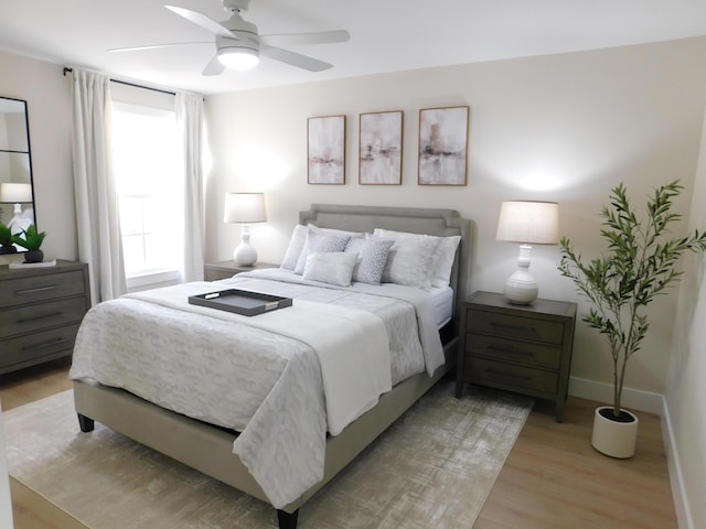 bedroom with light wood finished floors, ceiling fan, and baseboards