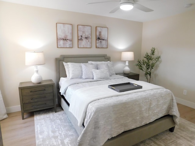 bedroom with a ceiling fan, light wood-style floors, and baseboards