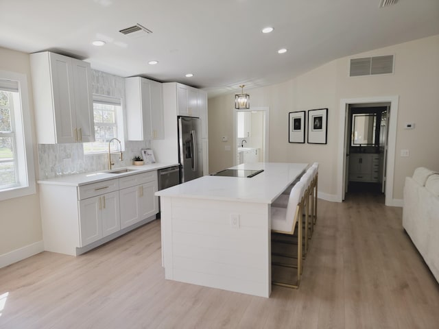 kitchen with visible vents, appliances with stainless steel finishes, light countertops, and decorative backsplash