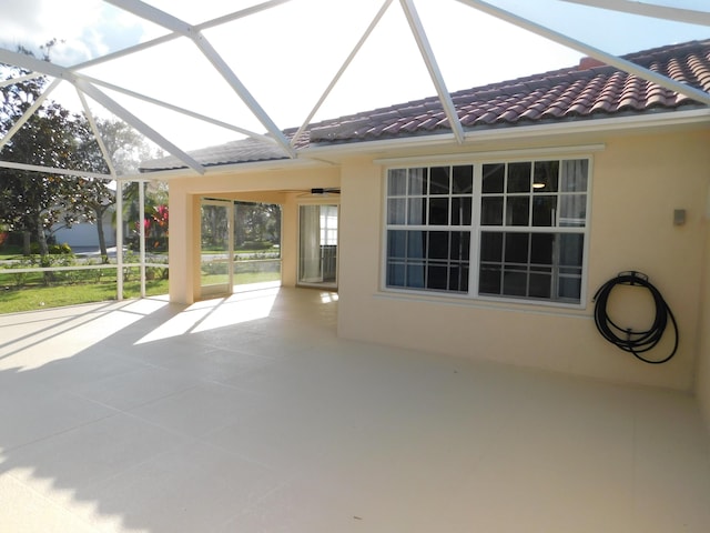 view of patio with glass enclosure and ceiling fan