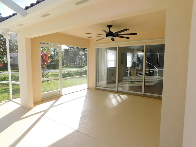 unfurnished sunroom with ceiling fan