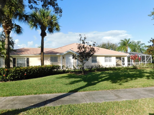 single story home with glass enclosure, stucco siding, a front yard, and a tiled roof