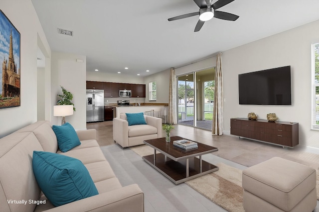 living room featuring ceiling fan and sink