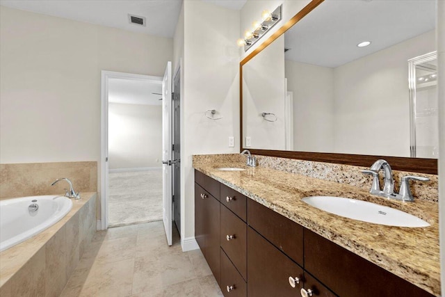 bathroom featuring vanity and tiled bath