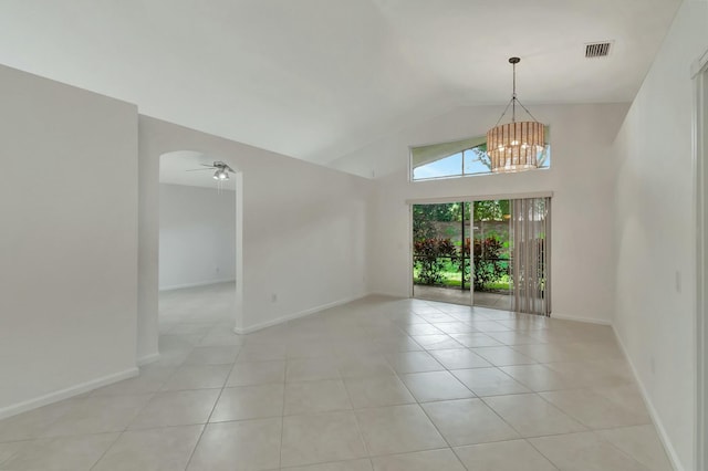 empty room with lofted ceiling, light tile patterned flooring, and ceiling fan with notable chandelier