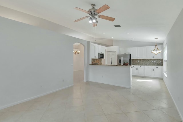 kitchen with backsplash, vaulted ceiling, appliances with stainless steel finishes, white cabinetry, and kitchen peninsula