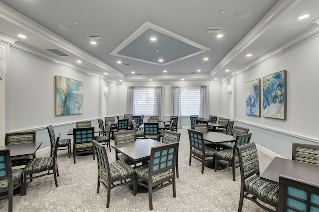 dining area featuring a raised ceiling and ornamental molding