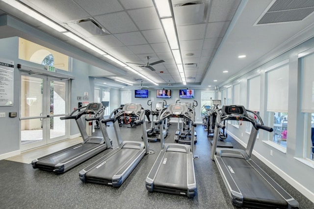 workout area with french doors, a paneled ceiling, and ceiling fan