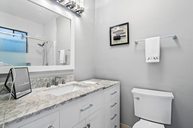 bathroom featuring a shower, vanity, and toilet