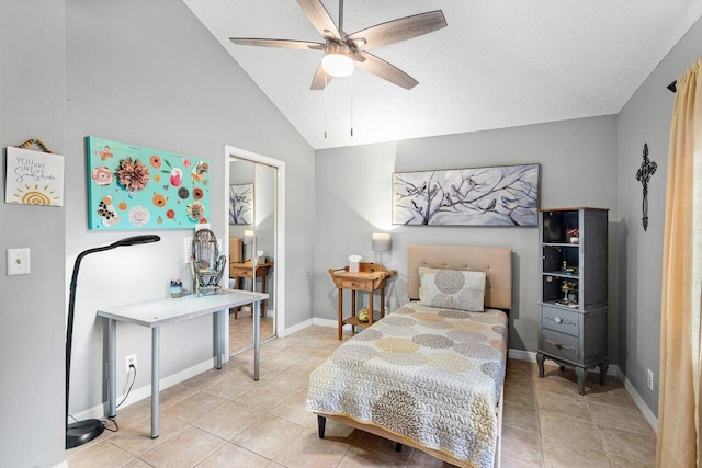 tiled bedroom featuring a textured ceiling, vaulted ceiling, and ceiling fan