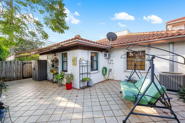 rear view of house with central AC and a patio area