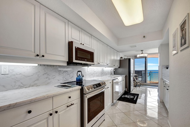 kitchen featuring white cabinets, sink, stainless steel appliances, and a water view