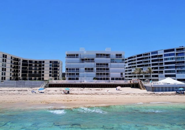 view of swimming pool with a water view and a beach view