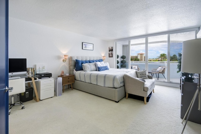 carpeted bedroom featuring expansive windows, access to exterior, and a textured ceiling