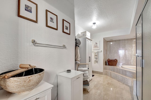 bathroom featuring a textured ceiling and a tub