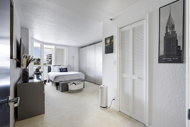 carpeted bedroom with floor to ceiling windows and a textured ceiling