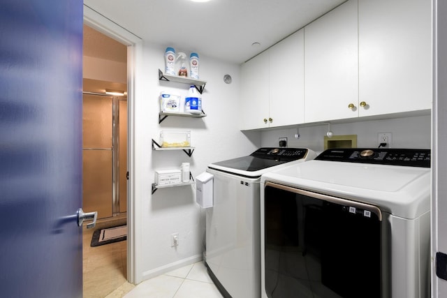 washroom with light tile patterned flooring, cabinets, and separate washer and dryer