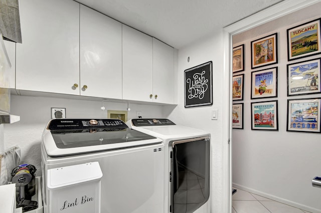 laundry area featuring cabinets, washer and clothes dryer, and light tile patterned flooring