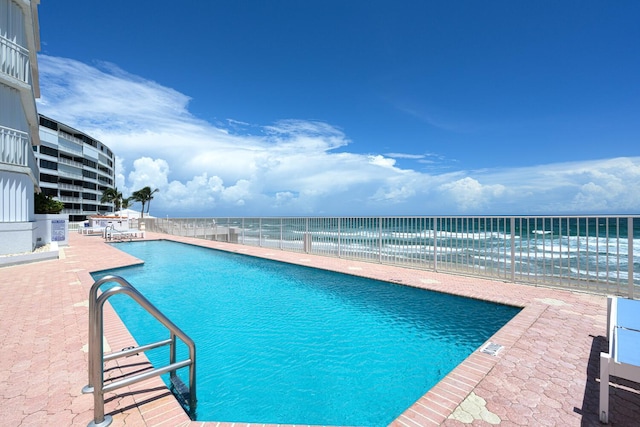 view of swimming pool featuring a patio area and a water view