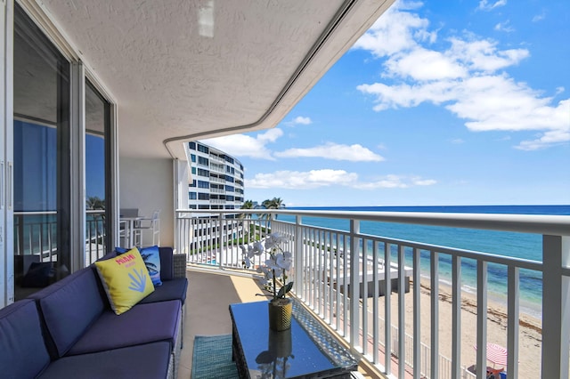 balcony featuring a water view and a view of the beach