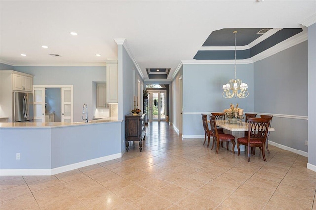 dining room featuring an inviting chandelier, sink, ornamental molding, and light tile patterned flooring