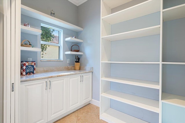 bar featuring white cabinets and light tile patterned flooring