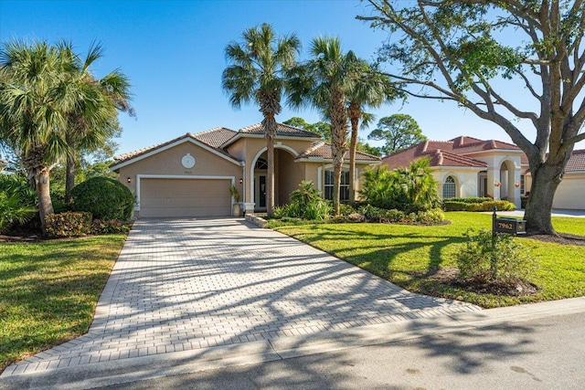 mediterranean / spanish home featuring a garage and a front lawn