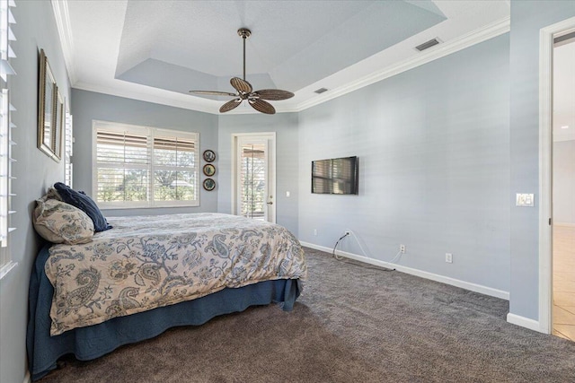 carpeted bedroom with ornamental molding, access to exterior, ceiling fan, and a tray ceiling