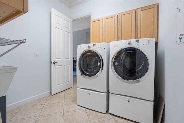 washroom featuring light tile patterned floors, ornamental molding, cabinets, and washing machine and clothes dryer