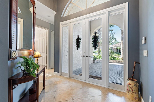 entrance foyer with light tile patterned flooring, ornamental molding, and french doors