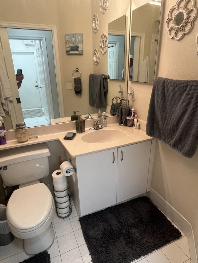 bathroom with tile patterned flooring, vanity, and toilet