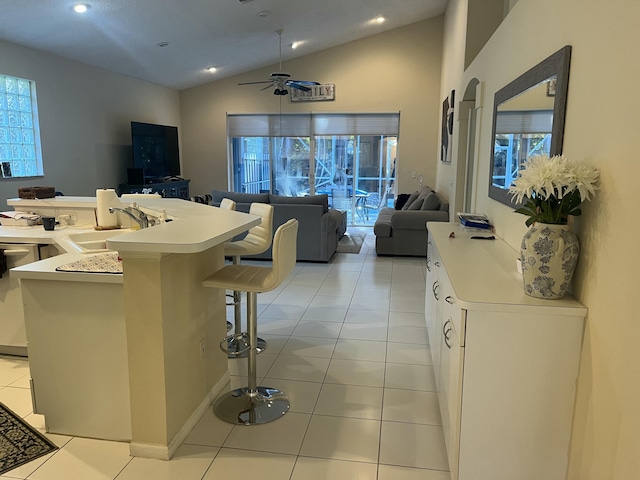 kitchen featuring dishwasher, sink, a breakfast bar area, white cabinets, and light tile patterned floors