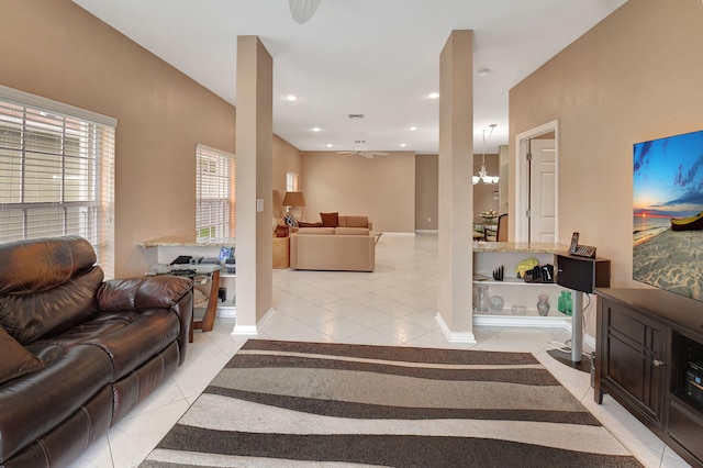 living room featuring ceiling fan with notable chandelier and light tile patterned floors