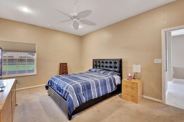 bedroom featuring a textured ceiling, ceiling fan, and light carpet